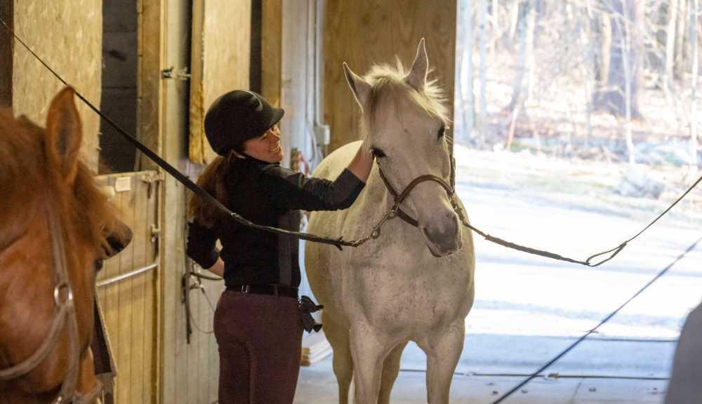 A student petting a horse