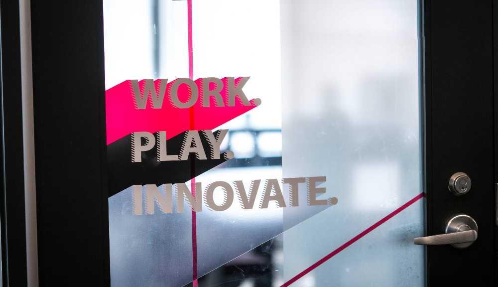 A door in the innovation studio with the motto "Work, play, innovate"