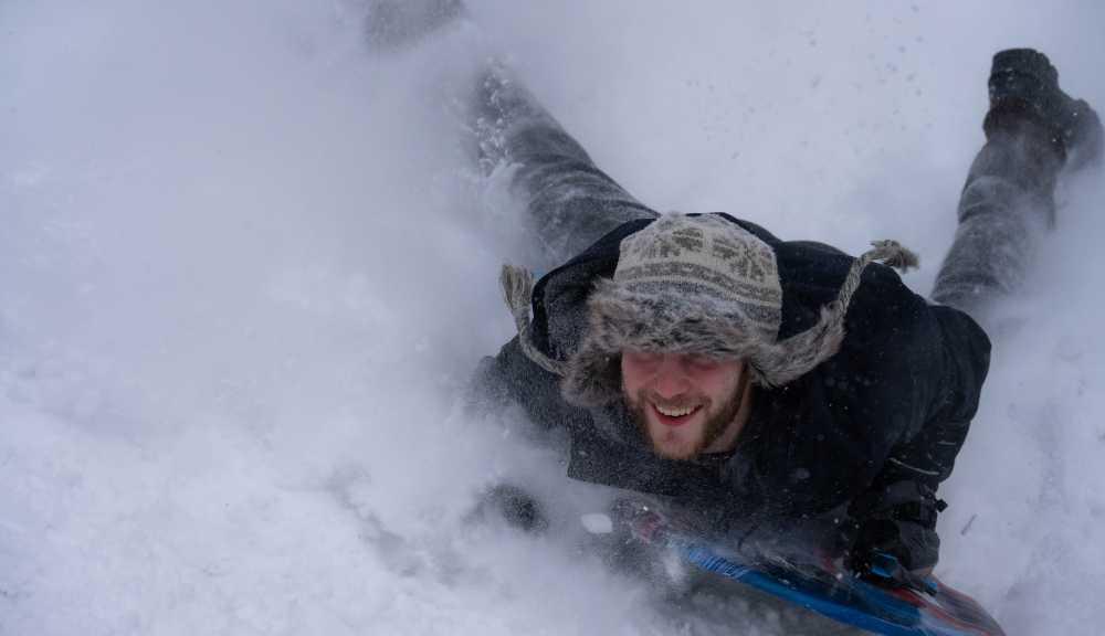 A man sledding down a snowy hill