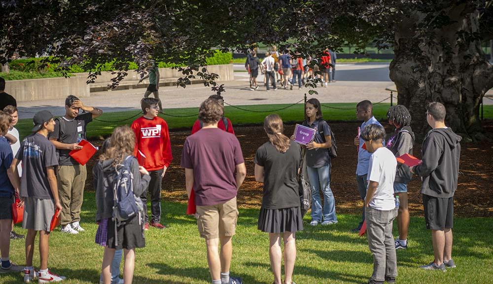 A group of new students gathers under the beech tree.