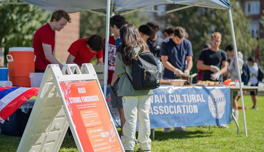 Students work under a tent on the Quad for a Maui fundraiser.