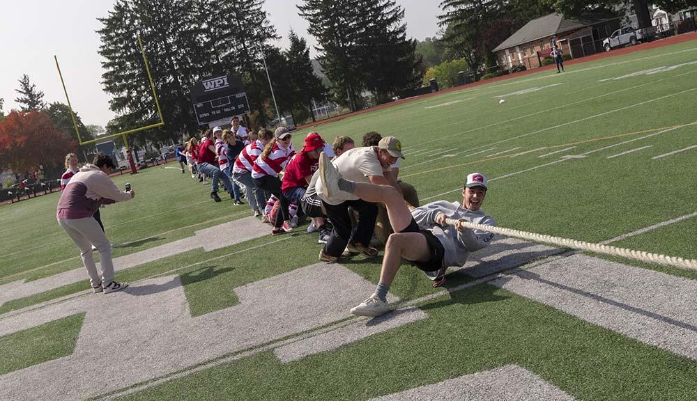 Students participate in the annual rope pull tradition on the football field.