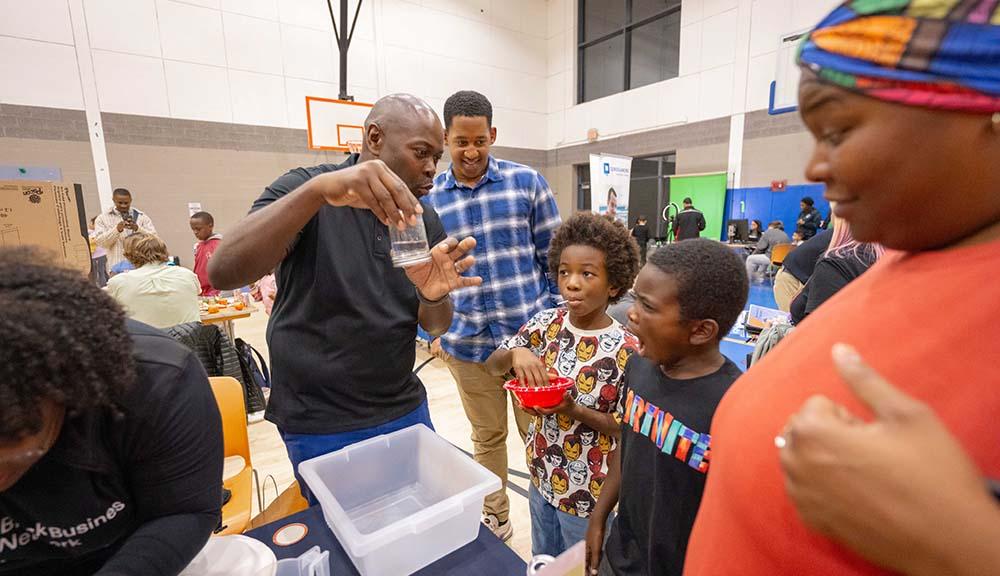 Attendees of a STEM fair engage in an activity.