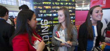 Female alumna talking to female student at the career fair