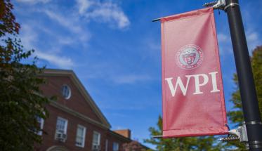 A red WPI banner with a blue sky in the background.