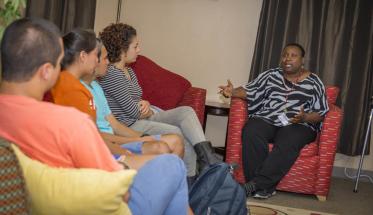 Charlana Simmons (right) in discussion with students at the Office of Multicultural Affairs.