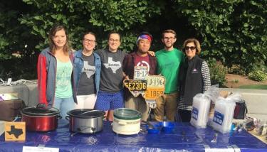 Students with Laurie Leshin behind their fundraising table near the campus fountain.