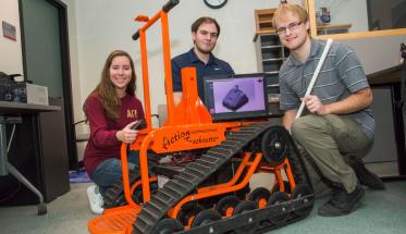 From left, seniors Marissa Bennett, Ken Quartuccio, and Jeff Tolbert with the Action Trackchair they are using as the base for their security robot