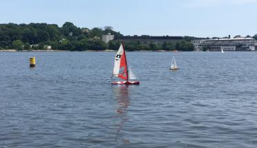 WPI’s sailboat (center) crosses the finish line on another autonomously completed lap during the six-hour endurance test in 2017.