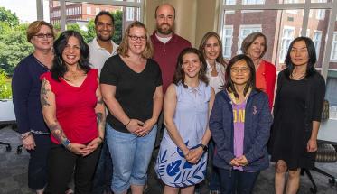 A group photo of the IPBL team that attended this year's Institute on Project-Based Learning. They're all wearing casual clothing, and are standing in front of large windows in the Rubin Campus Center.