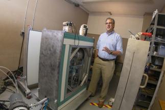 WPI professor David Medich stands next to the neutron generator he is developing for medical imaging.