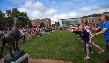 New students participate in a water balloon toss on the Quad in front of the proud goat Gompei statue.