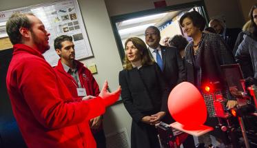 WPI researchers explain their latest technology to Karyn Polito and other guests while Laurie Leshin looks on.