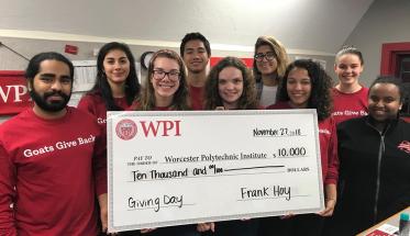 Members of the WPI community hold up an oversized check for $10,000 made out to WPI from Foisie Business School professor Frank Hoy.