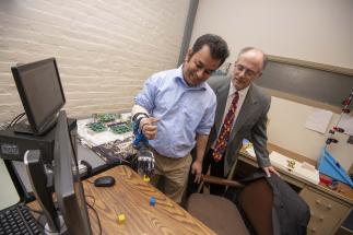 Ted Clancy (right), professor of electrical and computer engineering at WPI, is developing wireless sensors to communicate with a prosthesis.