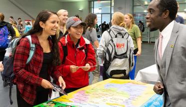 Students laugh together while learning about a project center at last year's Global Fair.