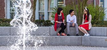 Students sitting by fountain talking