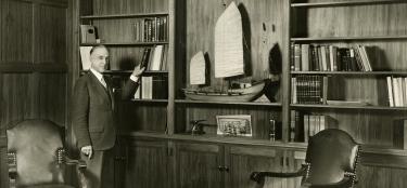 President Earle standing in a library room setting