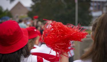 A student holds up a red pom-pom during WPI's bridge crossing event.