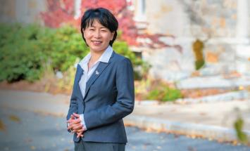 WPI president grace wang standing outside campus building