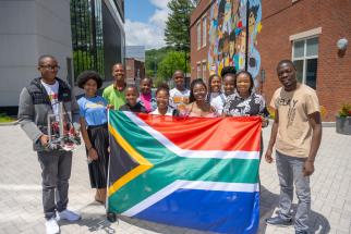 Robotics team members from Worcester, South Africa, show off their country’s flag and one of the robots they brought to WPI.
