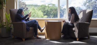 Two faculty members in a one-on-one conversation in a quiet area of the Rubin Campus Center