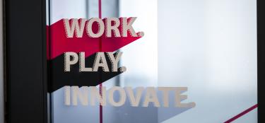 Photo of Work, Play, Innovate sign in the WPI Innovation Studio