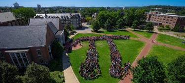 Aerial overhead of students arranged in a Pi symbol on the green quad.