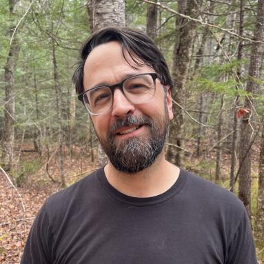 Image of Professor Pfeifer smiling in the woods