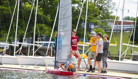 Members of the WPI SailBot team gather on the dock in front of their bot as they wait for the competition to begin.
