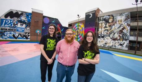 Sarah Kwatinetz, Joseph Cullon, and Brittany Goldstein stand in front of two of the many murals now decorating Worcester as part of Pow! Wow! Worcester.