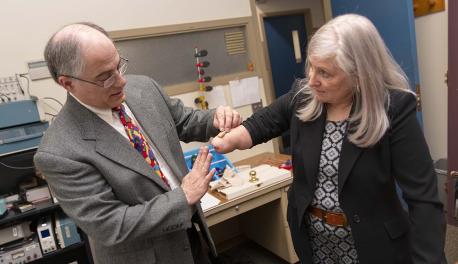 WPI professor Ted Clancy and consultant Debi Latour have had a longstanding partnership on prosthetics research. In this scene, Clancy places a wireless sensor on Latour’s arm.