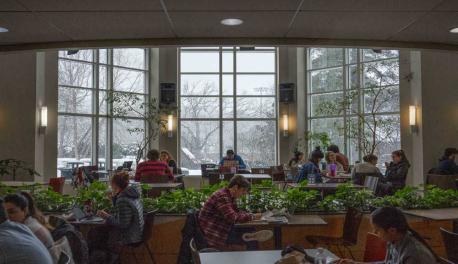 Students work in the Campus Center while it snows outside.