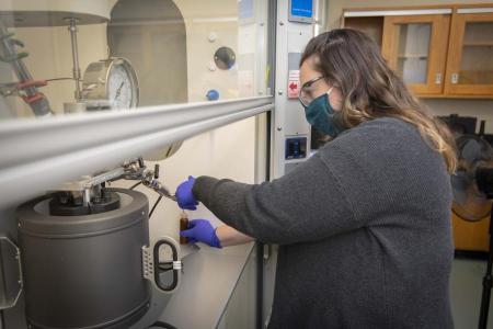 A photo of Heather LeClerc working under a fume hood
