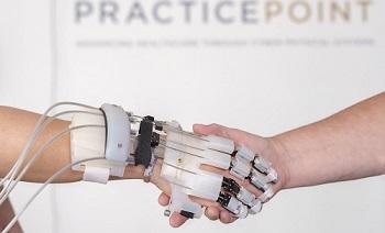A robotic hand shakes a human hand.