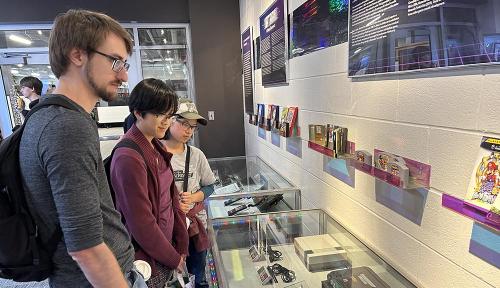 Visitors view video game console exhibit at WPI library.