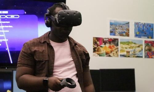 WPI student wearing a virtual reality headset and holding a controller.