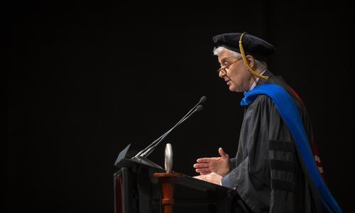 Professor Mark Richman delivers a welcome speech from the podium on stage at President Wang's inauguration.