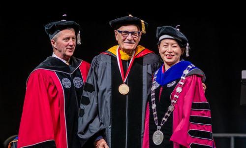 WPI Board of Trustees chairman Bill Fitzgerald, WPI President Grace Wang, and WPI Presidential Medal recipient Diran Apelian stand together on stage 
