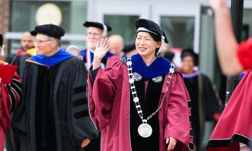 WPI President Grace Wang waves to community members as she walks toward the inauguration reception