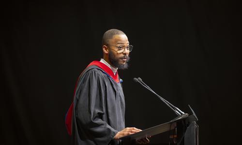 Rev. Kalvin Cummings stands at a podium while welcoming President Grace Wang on behalf of all WPI staff.