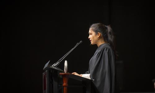 Gabriella Rios '24 stands at the podium while delivering a welcome speech to President Grace Wang at the inauguration ceremony