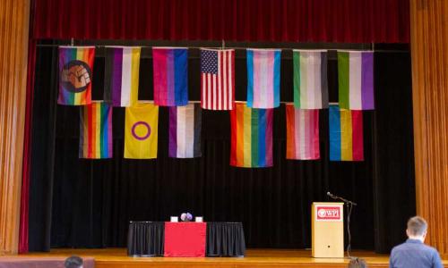 A photo of LGBTQIAP+ flags hanging in Alden Memorial before an event.